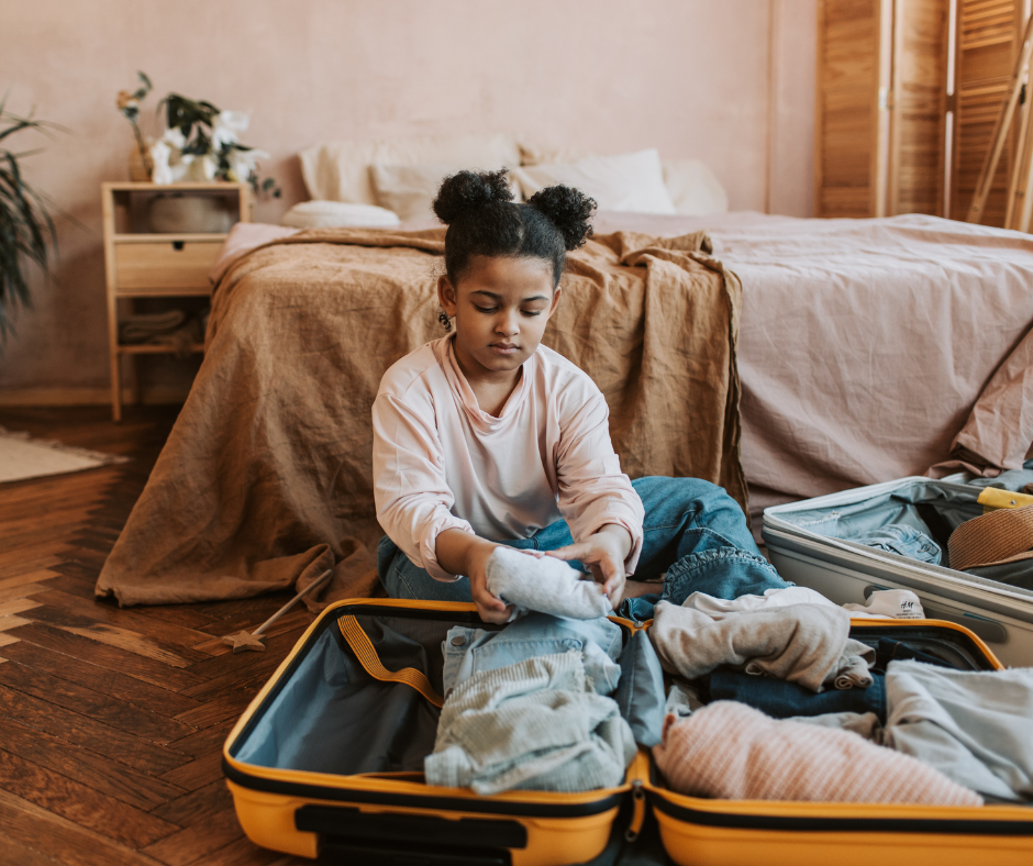 young girl packing a suit case becasue of parental relocation