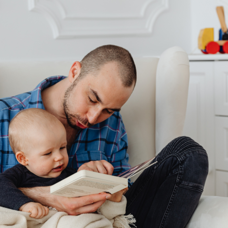 Father reading to their baby after a paternity attorney in Pinellas County
