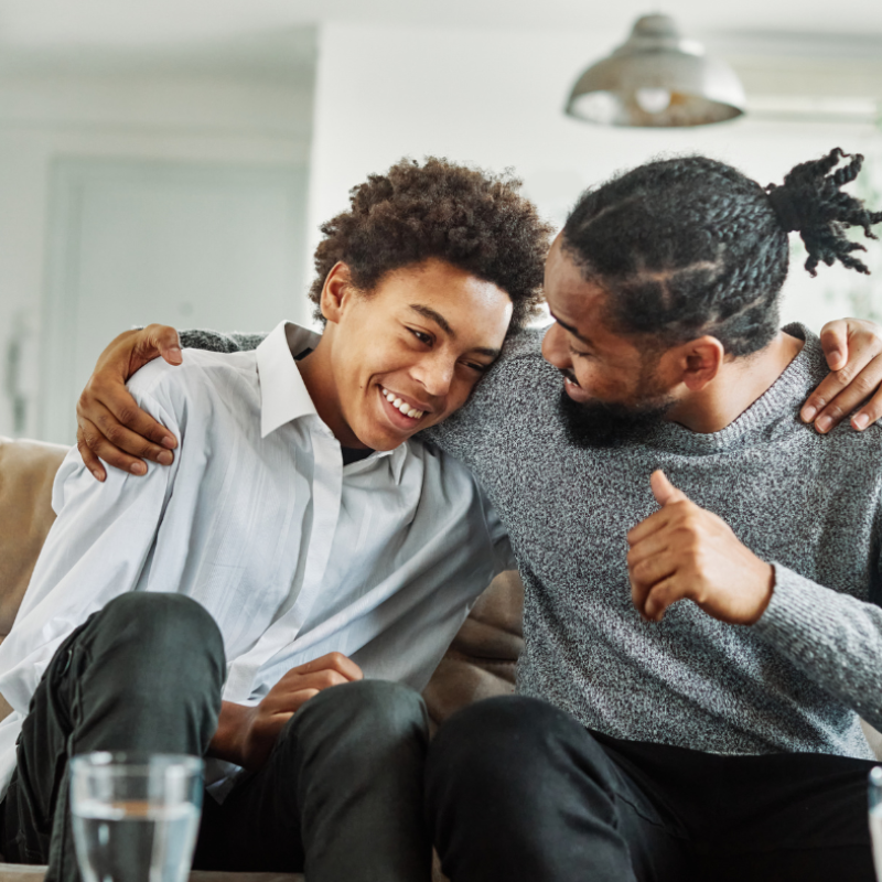 child custody attorney Pinellas County, father sitting with his son on a couch laughing